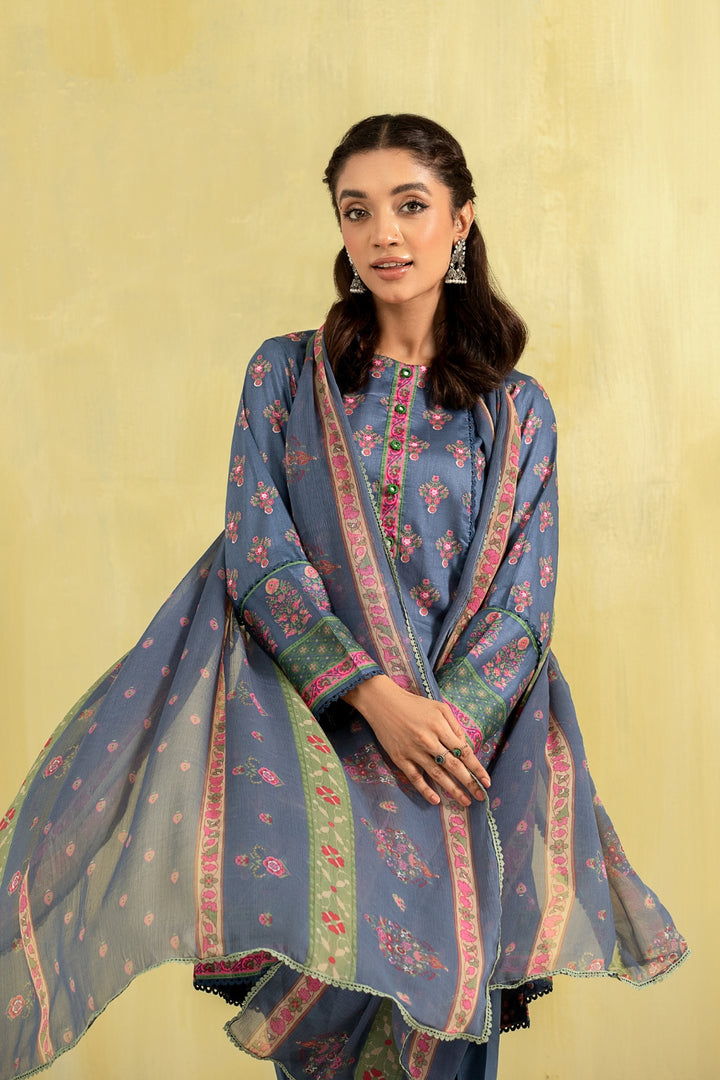 A girl is wearing a blue printed lawn outfit with a chiffon dupatta.