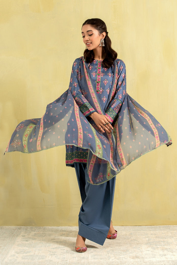 A girl is wearing a blue printed lawn outfit from Ittehad with a chiffon dupatta.