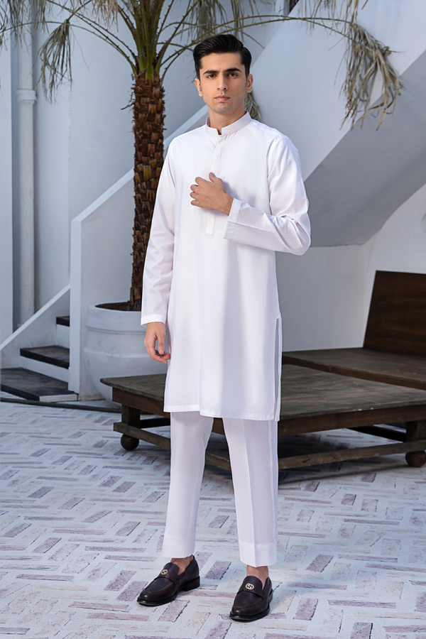 a man wearing an ittehad white kurta posing for a photo.	